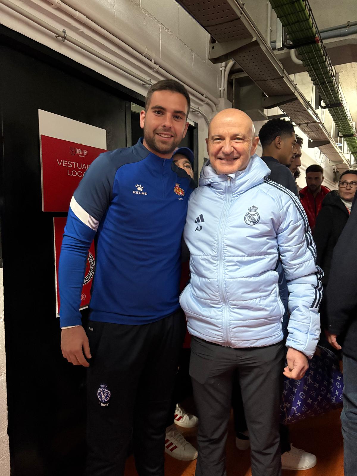 Antonio posa junto a otro profesional en un recinto deportivo.